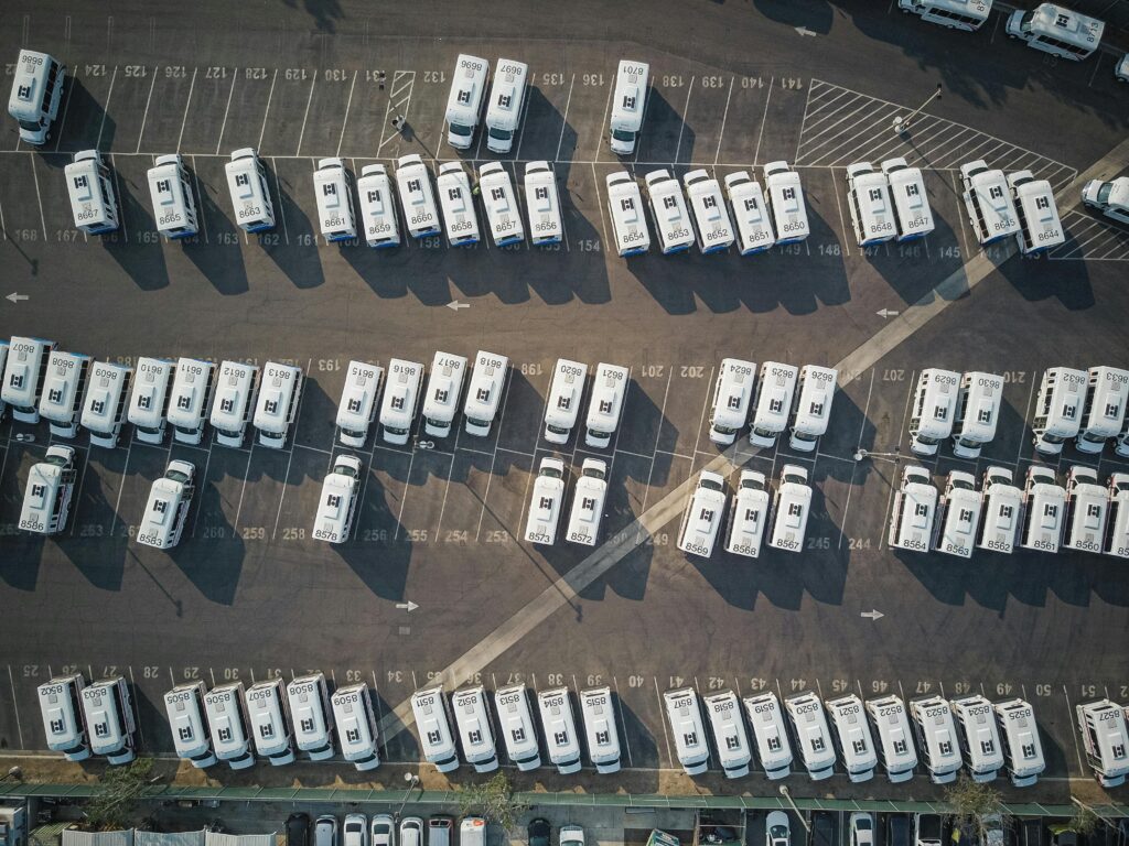 Pedestrians walking through a parking lot while cars yield the right of way.