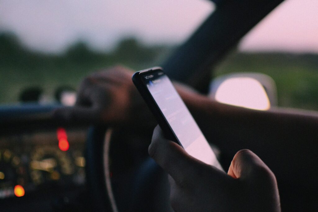 Driver looking at phone while driving, unaware of pedestrian crossing ahead